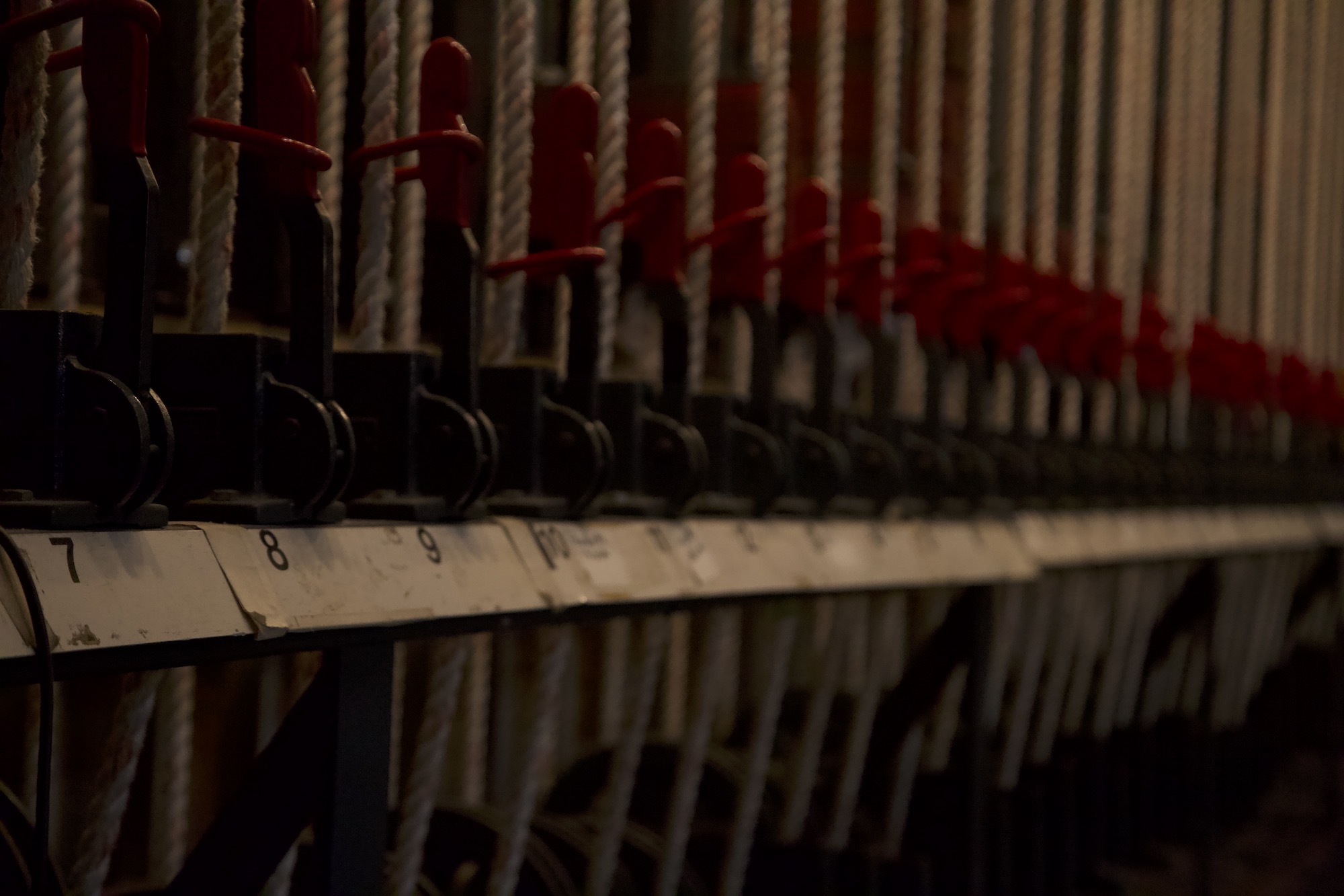 A close-up of the fly rail rope-lock cleats lined up backstage