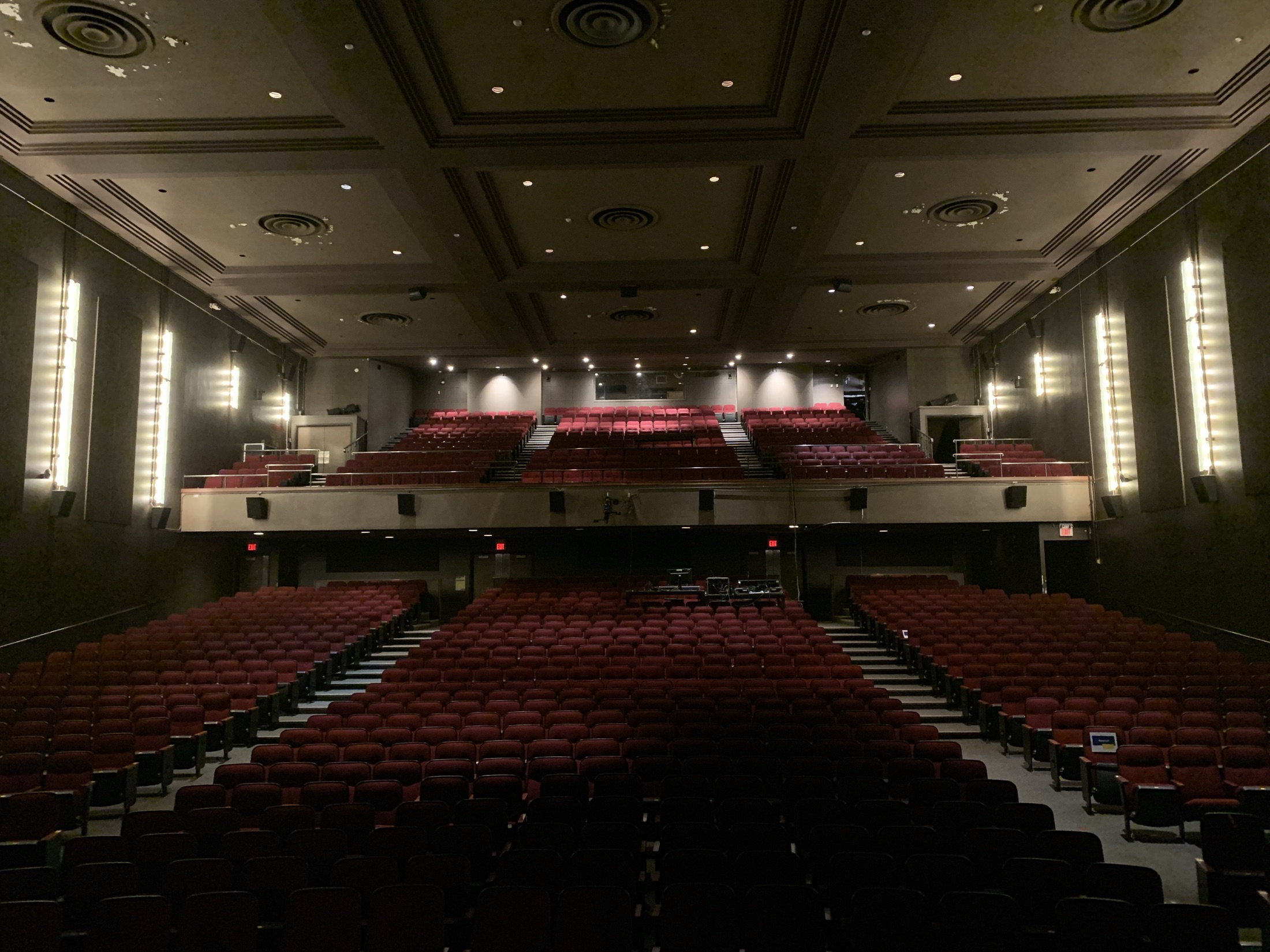The empty auditorium with reserved seat cards and dramatic side lighting
